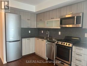 Toronto (Little Portugal) condo for rent - A kitchen with a stainless steel refrigerator, microwave, oven, and black countertops.