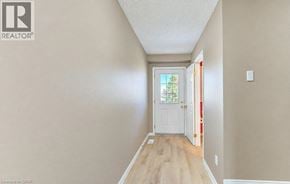 Kitchener apartment for rent - A hallway with a white door and a window.
