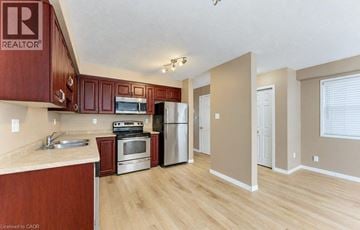 Kitchener apartment for rent - A kitchen with wooden cabinets and a refrigerator.