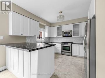 Vaughan (Vellore Village) apartment for rent - A modern kitchen with white cabinets and a black countertop.