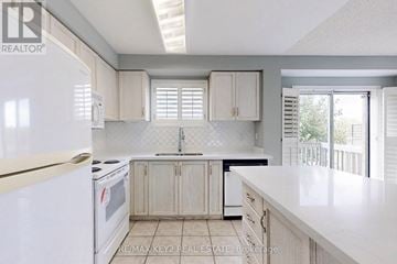 Vaughan (Maple) townhouse for rent - A kitchen with white appliances and cabinets.