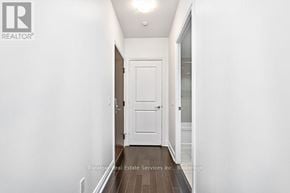 Toronto (Mimico) condo for rent - A hallway with a white door and wooden floor.
