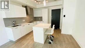 Toronto (Lansing-Westgate) condo for rent - A realtor photo of a kitchen with white cabinets and a black door.