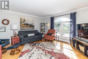 Huntsville townhouse for rent - A living room with a grey couch, a red chair, a lamp, and a painting on the wall.