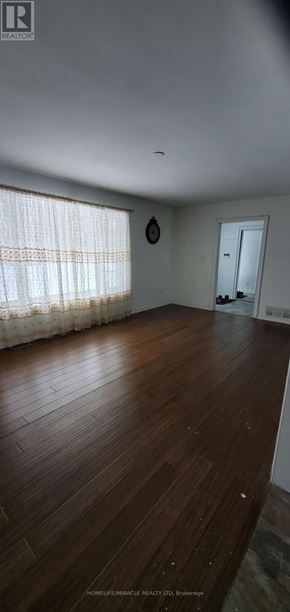 Pickering (Rosebank) apartment for rent - A room with wooden flooring and a window with curtains.