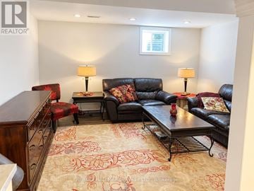 Milton (Wi Willmott) apartment for rent - A living room with a black couch and a rug with a red pattern.
