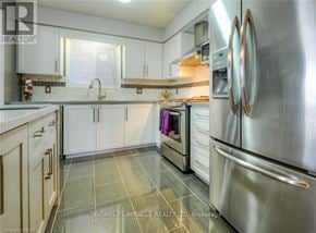 Kitchener apartment for rent - A kitchen with a stainless steel refrigerator and white cabinets.