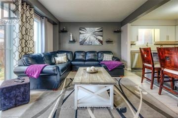 Kitchener apartment for rent - A living room with a black leather couch and a wooden coffee table.