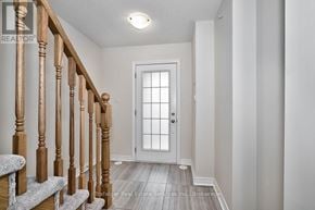 Oakville (Wm Westmount) townhouse for rent - A white door is at the end of a hallway with a wooden staircase.