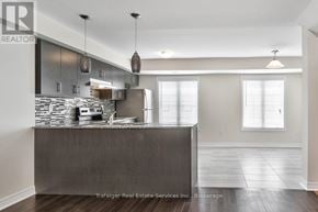 Oakville (Wm Westmount) townhouse for rent - A modern kitchen with a wooden island and pendant lights.