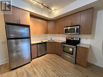 Toronto (Waterfront Communities) condo for rent - A kitchen with wooden cabinets and stainless steel appliances.