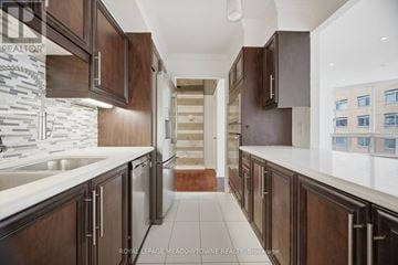 Toronto (Church-Yonge Corridor) condo for rent - A modern kitchen with dark wood cabinets and white countertops.