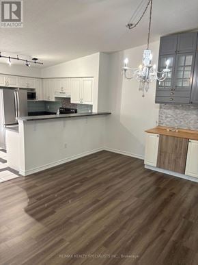 Milton (De Dempsey) condo for rent - A kitchen with white cabinets and a wooden island.