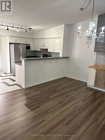 Milton (De Dempsey) condo for rent - A kitchen with white cabinets and a wooden floor.
