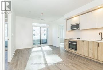 Vaughan (Vaughan Corporate Centre) condo for rent - A spacious kitchen with wooden cabinets and a microwave above the stove.
