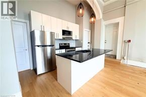 Hamilton apartment for rent - A modern kitchen with a black countertop and stainless steel appliances.