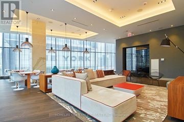 Toronto (Waterfront Communities) condo for rent - A living room with a white couch and a wooden coffee table.