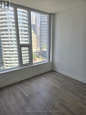 Toronto (Waterfront Communities) condo for rent - A room with a large window overlooking a cityscape.
