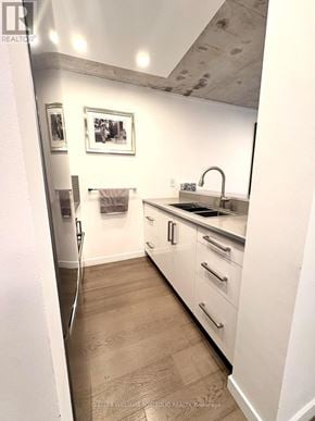 Toronto (Waterfront Communities) condo for rent - A modern kitchen with white cabinets and a wooden floor.