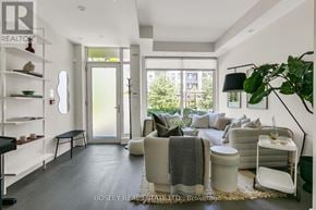 Toronto (Kensington-Chinatown) townhouse for rent - A modern living room with a large window and a view of trees outside.