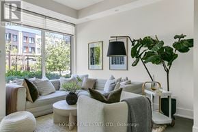 Toronto (Kensington-Chinatown) townhouse for rent - A living room with a large window, a white couch, and a potted plant.