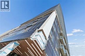 Kitchener condo for rent - A modern building with a glass facade and a triangular roof.