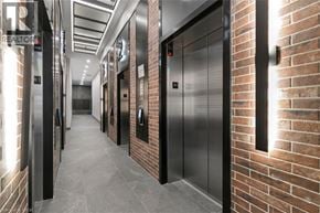 Kitchener condo for rent - A long hallway with elevators on the side of the wall.