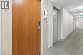 Kitchener condo for rent - A hallway with a wooden door on the left and a metal door on the right.