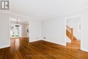 Toronto (Birchcliffe-Cliffside) apartment for rent - A room with wooden floors and white walls, with a staircase visible in the background.