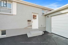 Oshawa (O'neill) apartment for rent - A white house with a garage door and a window.