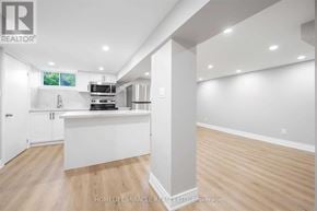 Oshawa (O'neill) apartment for rent - A well-lit, spacious kitchen with white cabinets and a wooden floor.