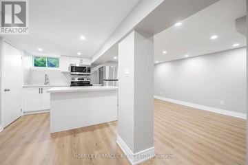 Oshawa (O'neill) apartment for rent - A well-lit, spacious kitchen with white cabinets and a wooden floor.