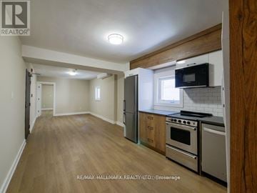 Toronto (Playter Estates-Danforth) apartment for rent - A kitchen with a refrigerator, oven, and microwave.