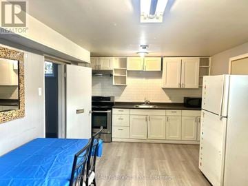 Toronto (Woburn) apartment for rent - A kitchen with white cabinets and a blue tarp on the floor.