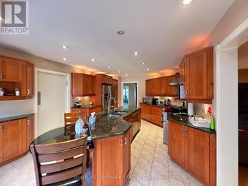 Richmond Hill (Bayview Hill) apartment for rent - A kitchen with wooden cabinets and a black countertop.