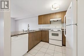 Centre Wellington (Fergus) condo for rent - A kitchen with white appliances and wooden cabinets.