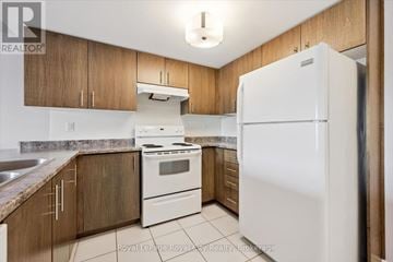 Centre Wellington (Fergus) condo for rent - A kitchen with wooden cabinets and a white refrigerator.