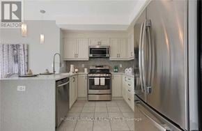 Clarington (Newcastle) apartment for rent - A modern kitchen with stainless steel appliances and white cabinets.