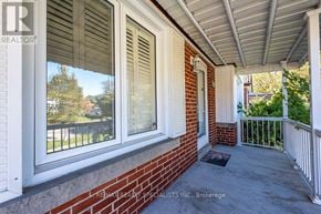 Toronto (Rexdale-Kipling) apartment for rent - A white house with a red brick wall and a porch.