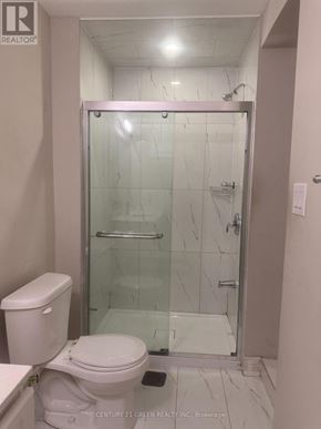Toronto (Clairlea-Birchmount) apartment for rent - A white toilet sits next to a walk-in shower.
