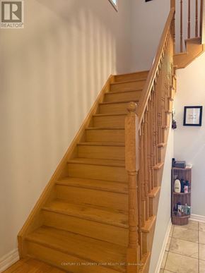 Brampton (Credit Valley) apartment for rent - A wooden staircase with a white wall and a picture frame on the wall.
