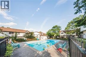 Kitchener townhouse for rent - A pool with a slide and a fence in front of a house.