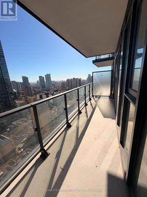 Toronto (Church-Yonge Corridor) condo for rent - A balcony with glass railings overlooking a cityscape.