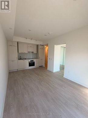 Toronto (Church-Yonge Corridor) condo for rent - A spacious kitchen with white cabinets and a wooden floor.