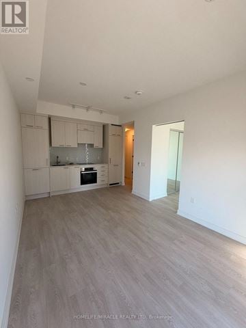 Toronto (Church-Yonge Corridor) condo for rent - A spacious kitchen with white cabinets and a wooden floor.
