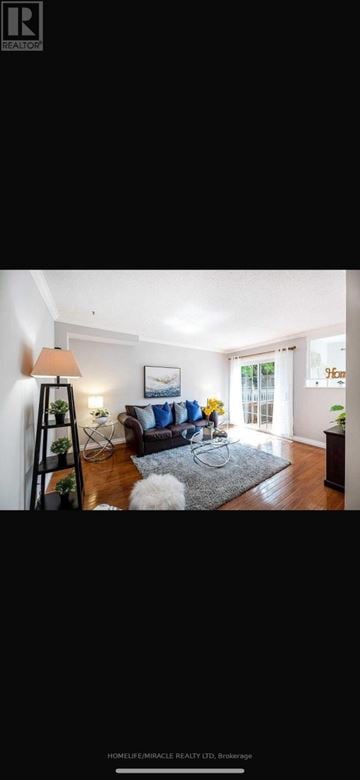 Oshawa (Mclaughlin) apartment for rent - A well-lit living room with a grey rug and a brown sofa.