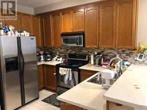 Brampton (Madoc) apartment for rent - A kitchen with wooden cabinets and a stainless steel refrigerator.