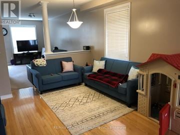 Brampton (Madoc) apartment for rent - A living room with a grey couch and a white pillow.