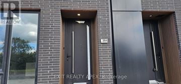 St. Catharines (Oakdale) townhouse for rent - The image shows a modern building with a glass window and a black door.