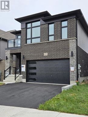 Waterloo apartment for rent - A modern house with a black garage door is for sale.